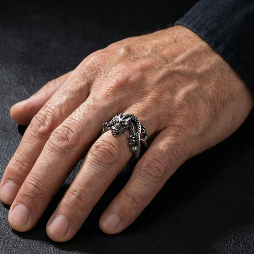 Close-up of a man's hand wearing a coiled dragon stainless steel ring.