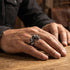 Man wearing a coiled dragon stainless steel ring.
