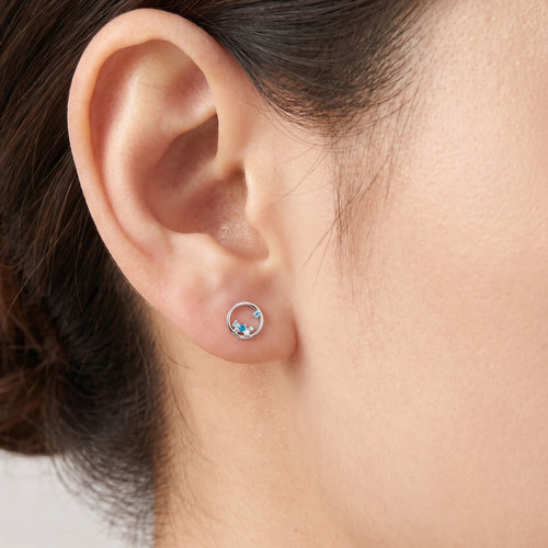 Woman wearing Engelsrufer cosmo circle blue CZ earrings.