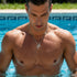 Man standing in swimming pool wearing faith cross & wing stainless steel necklace.