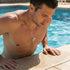 Man emerging from swimming pool wearing faith cross & wing stainless steel necklace.