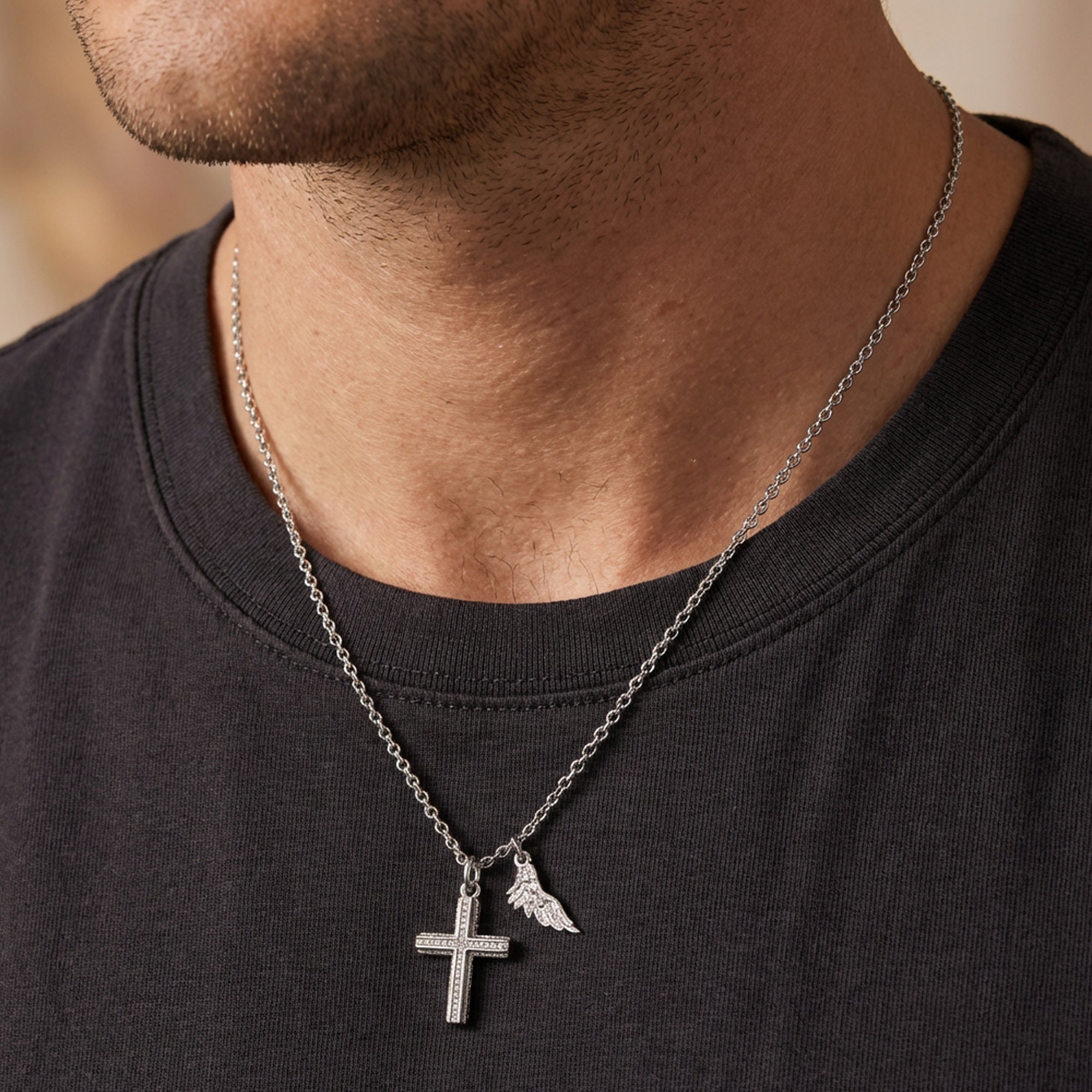 Man in a dark grey t-shirt wearing Save Brave faith cross & wing stainless steel necklace.