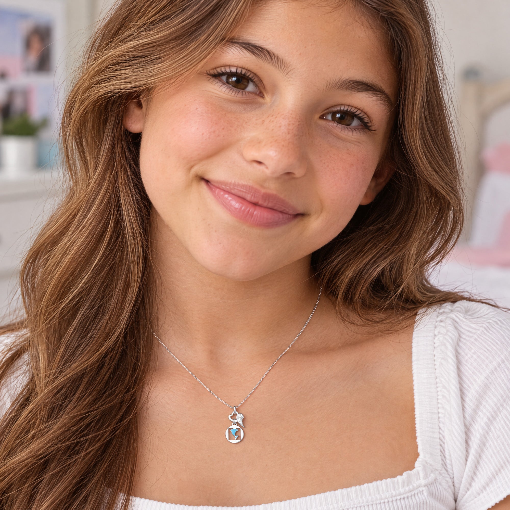 Young girl wearing Herzengel dolphin heart wing silver children's necklace.