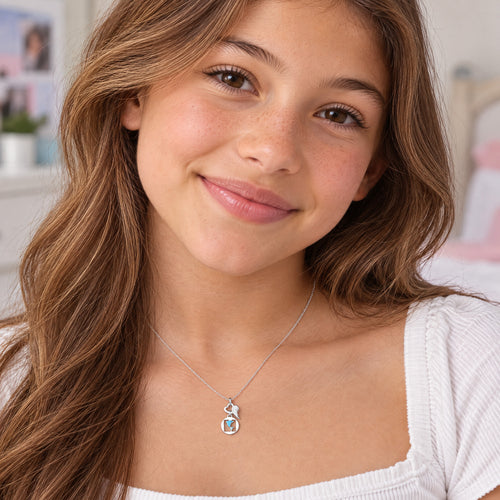 Young girl wearing Herzengel dolphin heart wing silver children's necklace.