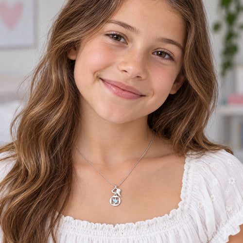 Young girl wearing Herzengel peace dove heart wing silver children's necklace.