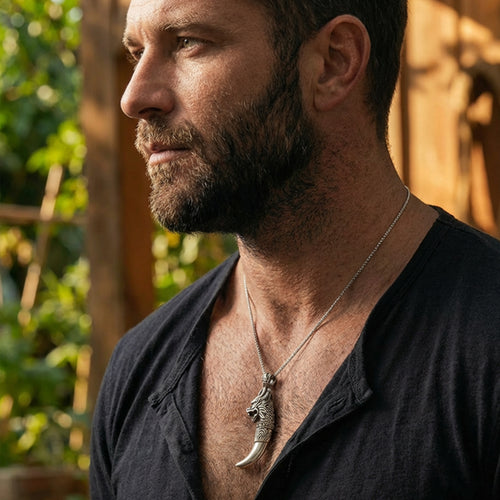 Man looking to the left wearing a sterling silver dragon tooth pendant.