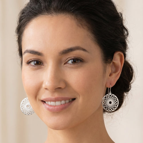 Woman wearing Engelsrufer dreamcatcher sterling silver hook earrings.