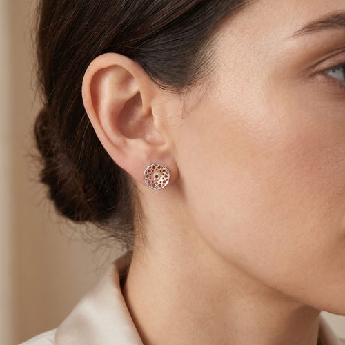 Woman wearing Engelsrufer dreamcatcher silver rose gold stud earrings.