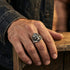 Close-up of man's hand with exoskeleton skull stainless steel ring.