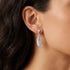 Close-up of side of woman's face wearing Engelsrufer feather sterling silver dangle earrings.