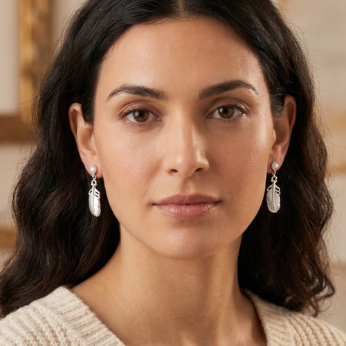 Woman wearing Engelsrufer feather sterling silver dangle earrings.