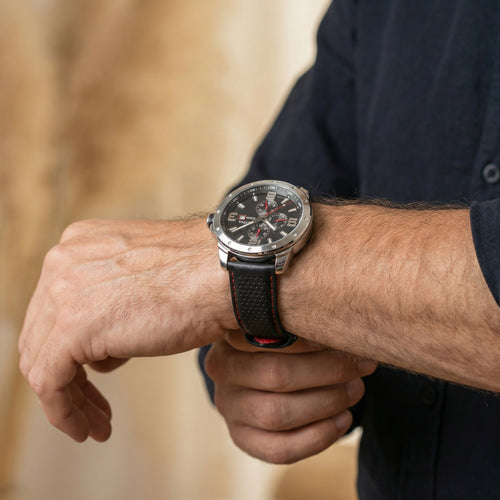 Man checking the time on his Festina men's red black dial multifunction leather watch.