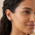 Woman wearing Engelsrufer filigree cage ball rose gold stud earrings.