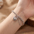 Woman wearing a filigree heart padlock CZ sterling silver belcher chain bracelet on her wrist.
