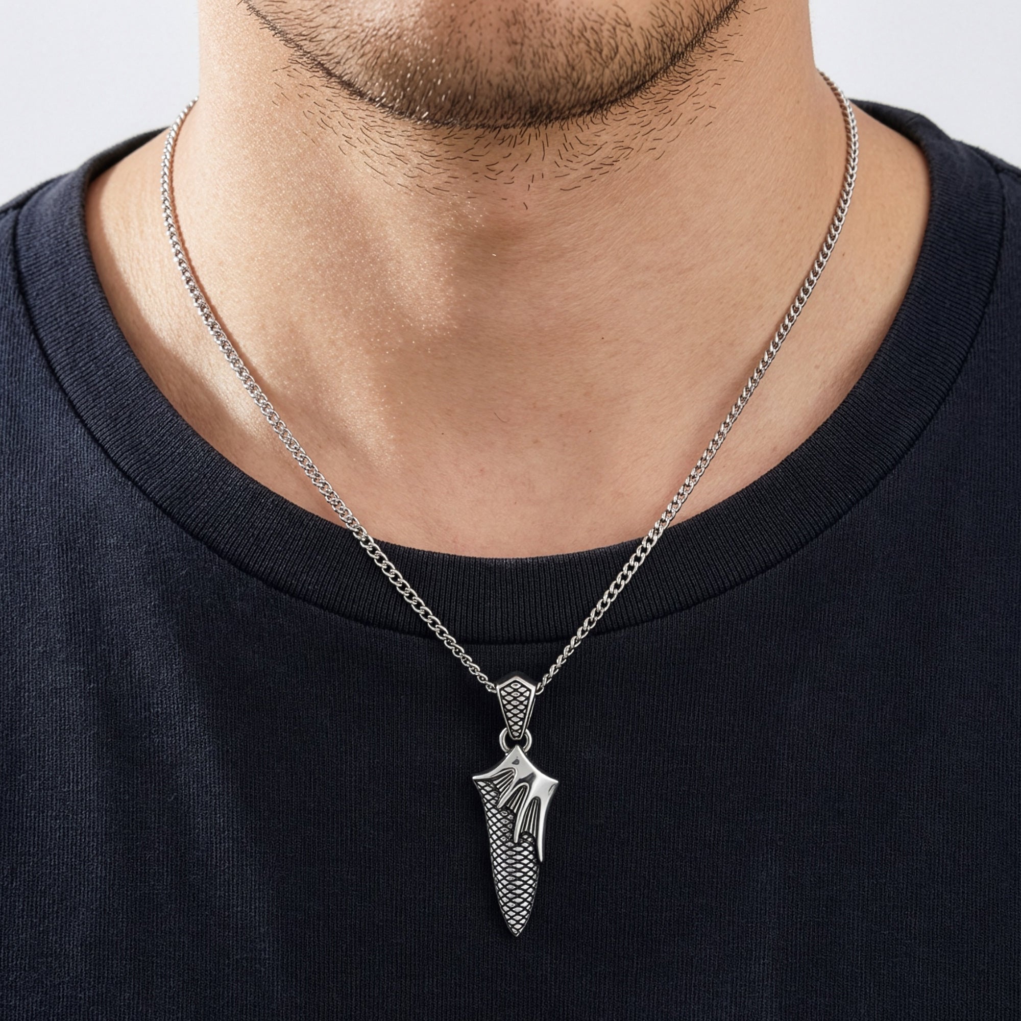 Close-up of man wearing flaming dagger stainless steel necklace.