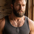 Close-up of man in a singlet wearing a fleur-de-lis dog tag necklace.
