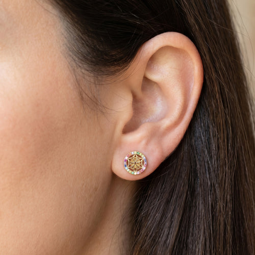 Woman wearing Engelsrufer flower of life gold rainbow CZ earrings.