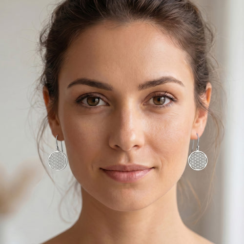 Woman wearing Engelsrufer flower of life silver hook earrings.