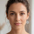 Woman wearing Engelsrufer flower of life silver hook earrings.