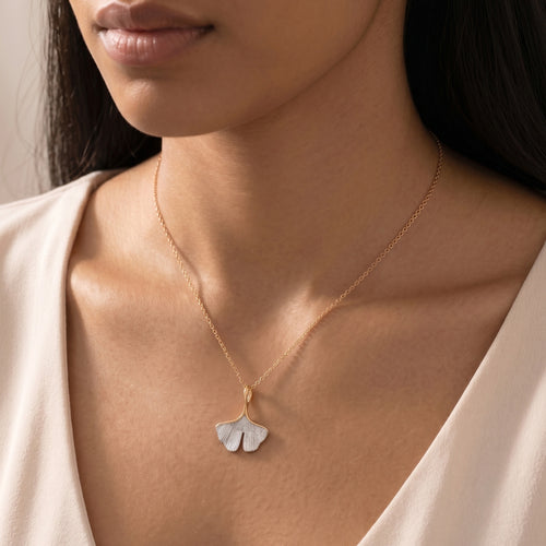 Woman wearing an Engelsrufer ginkgo leaf rose gold silver necklace.