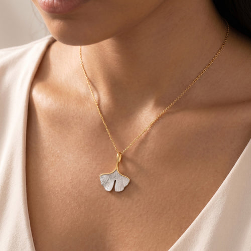 Woman wearing an Engelsrufer ginkgo leaf gold silver necklace.
