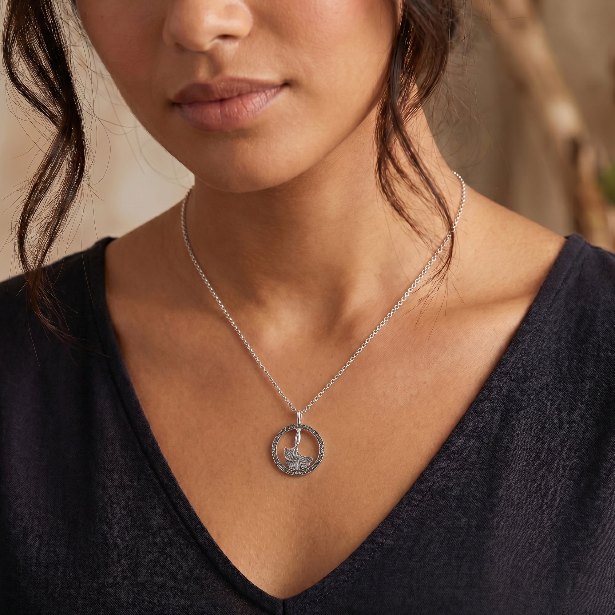 Woman wearing an Engelsrufer ginkgo leaf marcasite circle necklace.