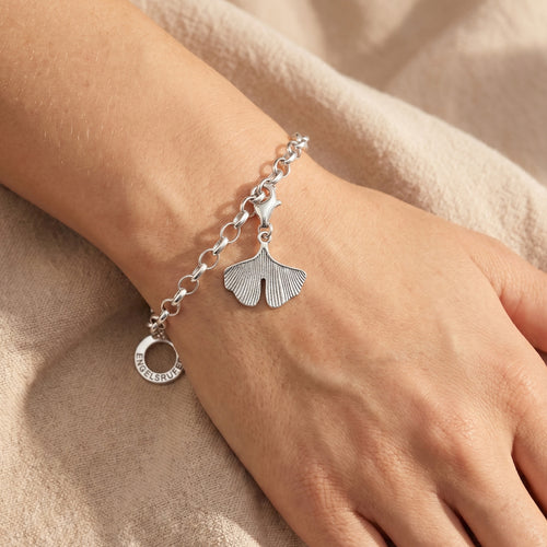Engelsrufer ginkgo silver charm attached to a bracelet being worn on a woman's wrist.