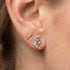 Close-up of woman wearing Engelsrufer moon & gold angel wing mismatch stud earrings.