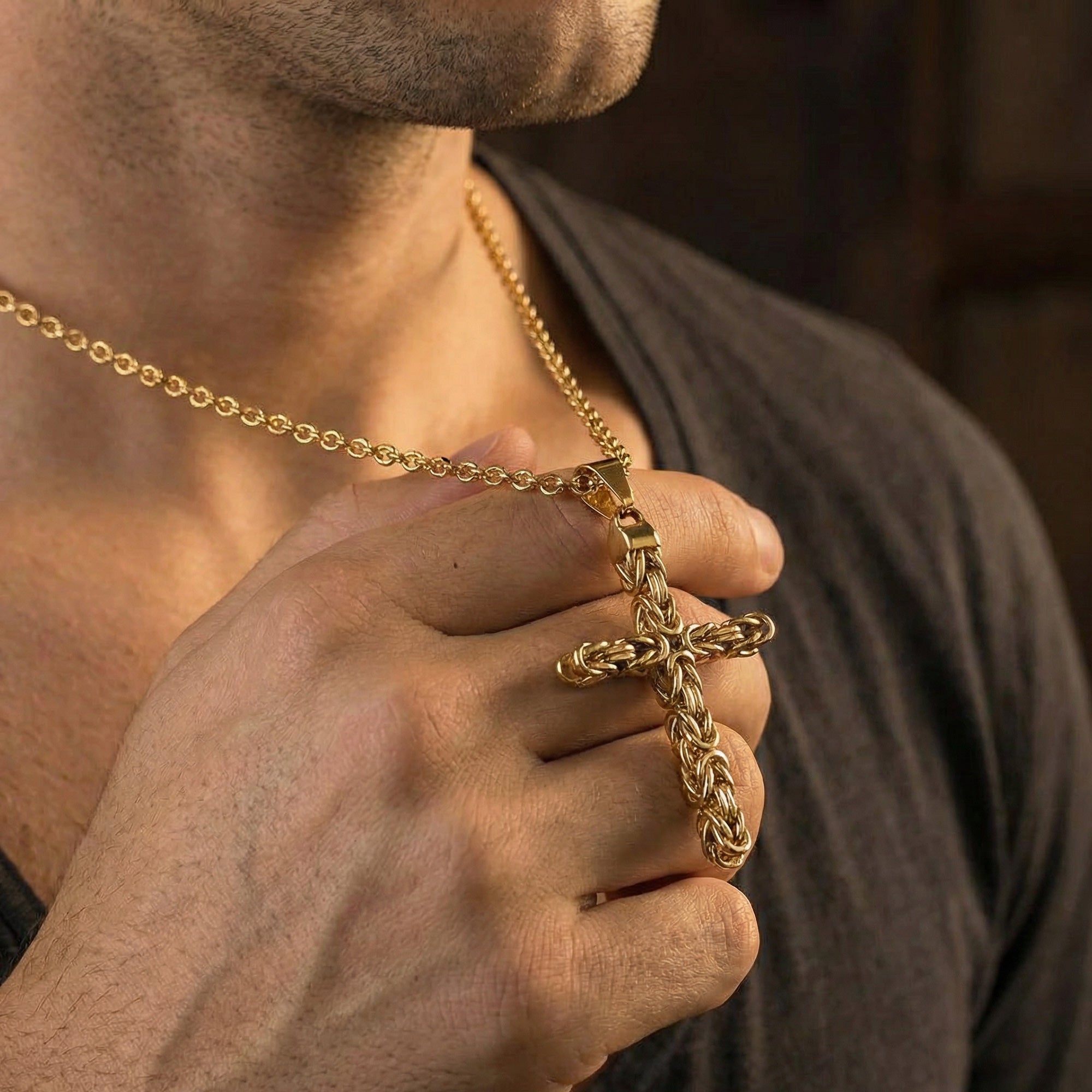 Close-up of man wearing Byzantine rope knot cross gold stainless steel necklace.