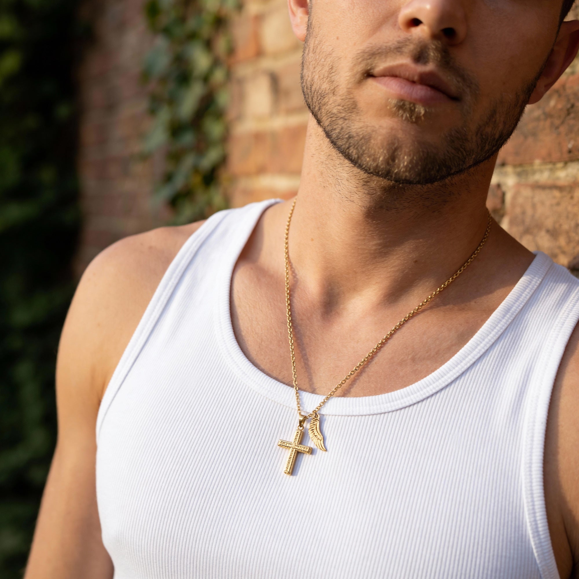 Man wearing faith cross & wing stainless steel gold necklace.