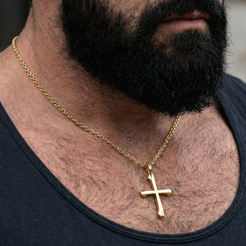 Bearded man in a singlet wearing barbed cross gold steel necklace.