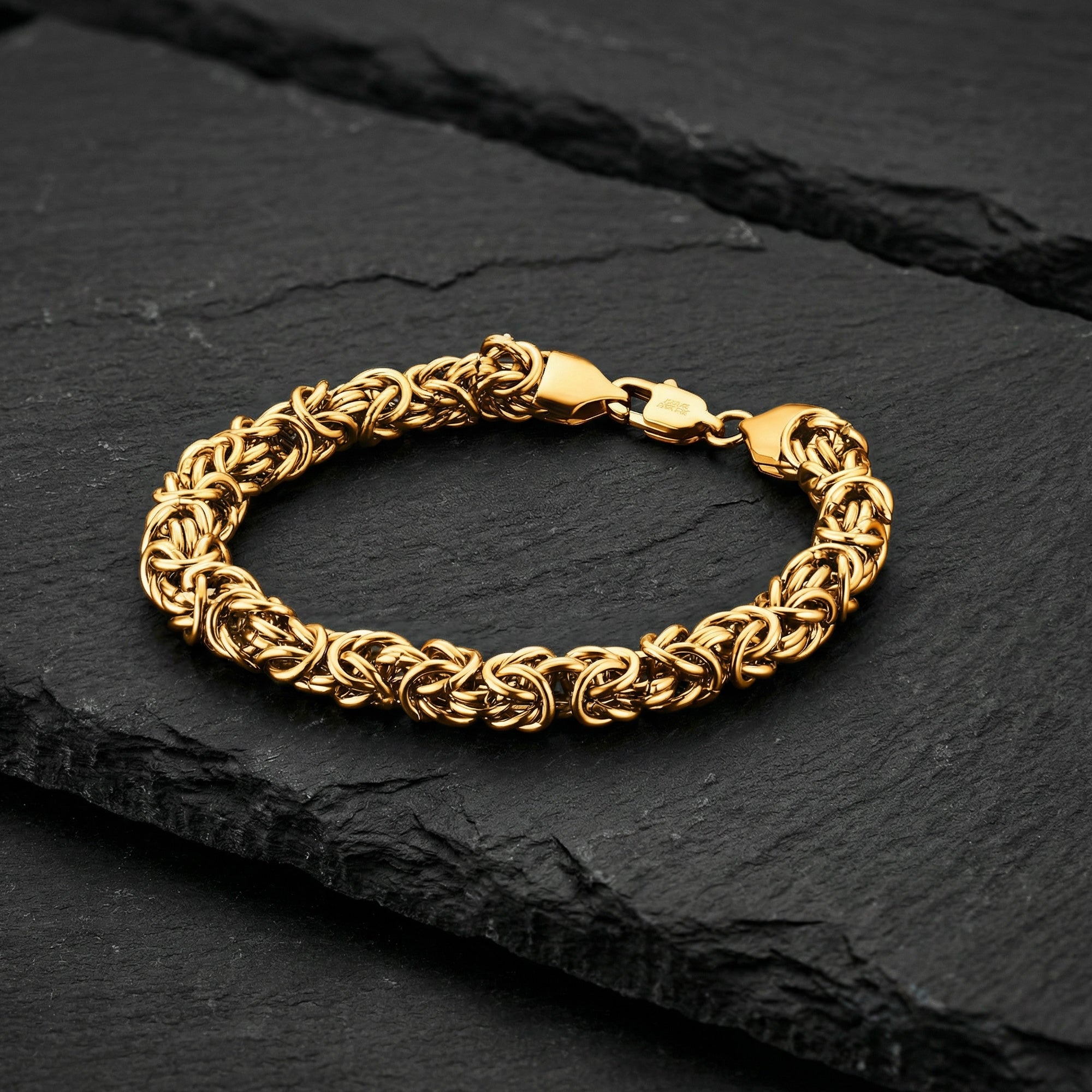 Byzantine chain men's gold steel bracelet on black slate.