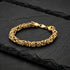 Byzantine chain men's gold steel bracelet on black slate.