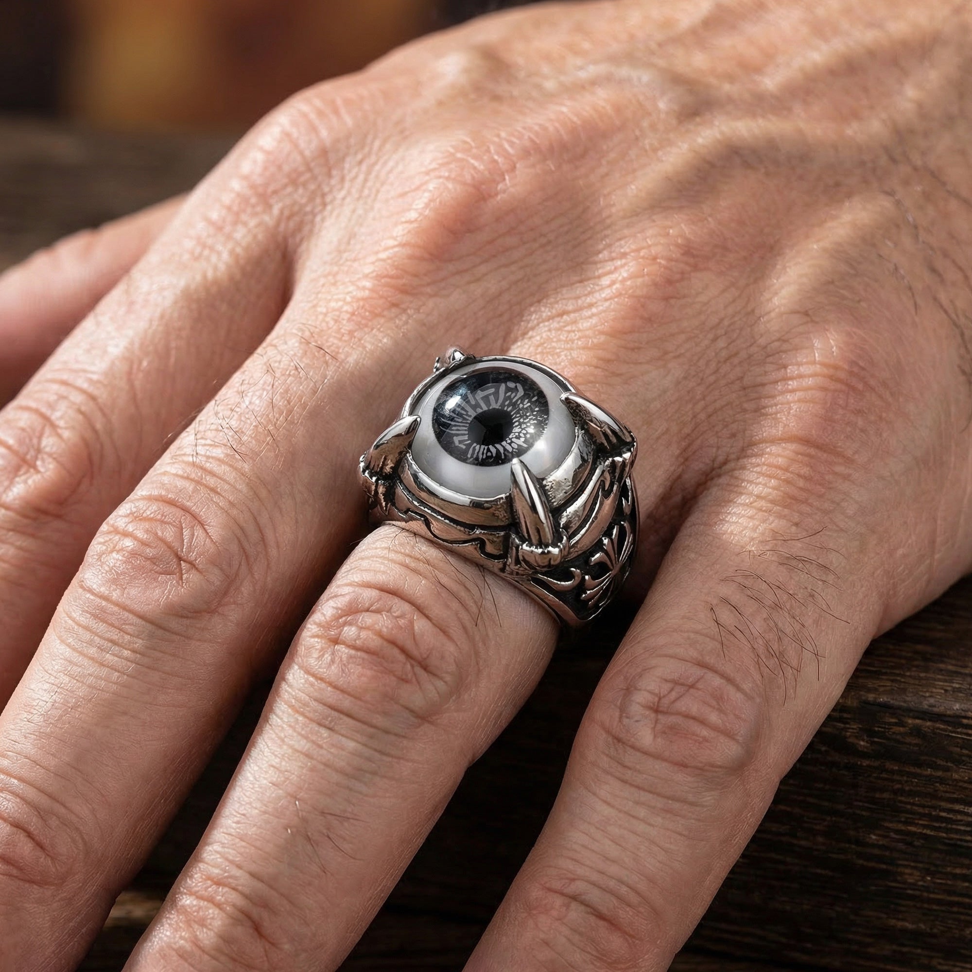 Close-up of man's hand wearing grey eyeball dragon claw stainless steel men's ring.