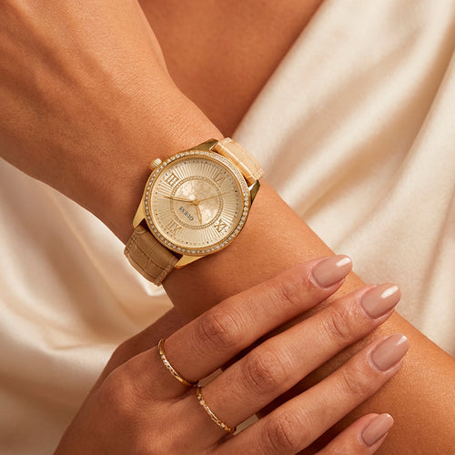 Woman wearing Guess Broadway gold ladies dress watch.