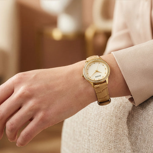 Woman wearing Guess Chelsea gold ladies leather dress watch.