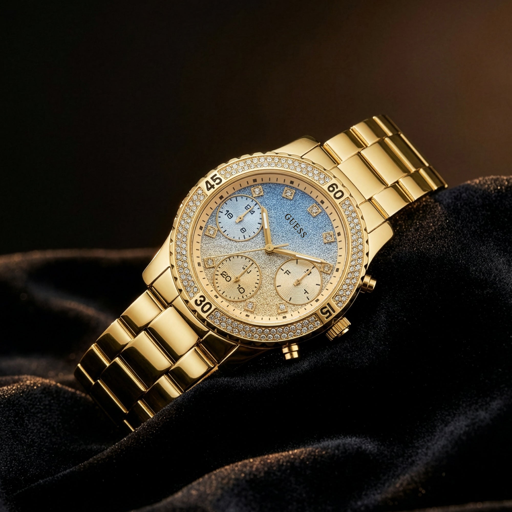 Guess Confetti gold ladies sport watch laying on black velvet.