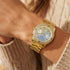 Woman wearing Guess Confetti gold ladies sport watch.