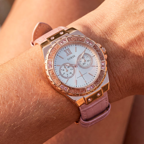 Woman wearing Guess Limelight rose gold ladies dress watch.
