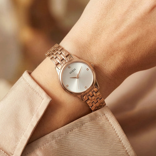 Woman wearing Guess Lady Wafer rose gold dress watch.