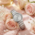 Guess Lady Wafer silver dress watch on a table with pink roses.