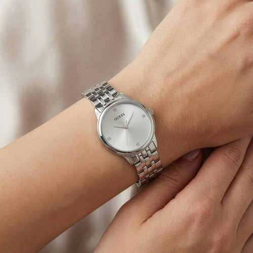 Woman wearing Guess Lady Wafer silver dress watch.