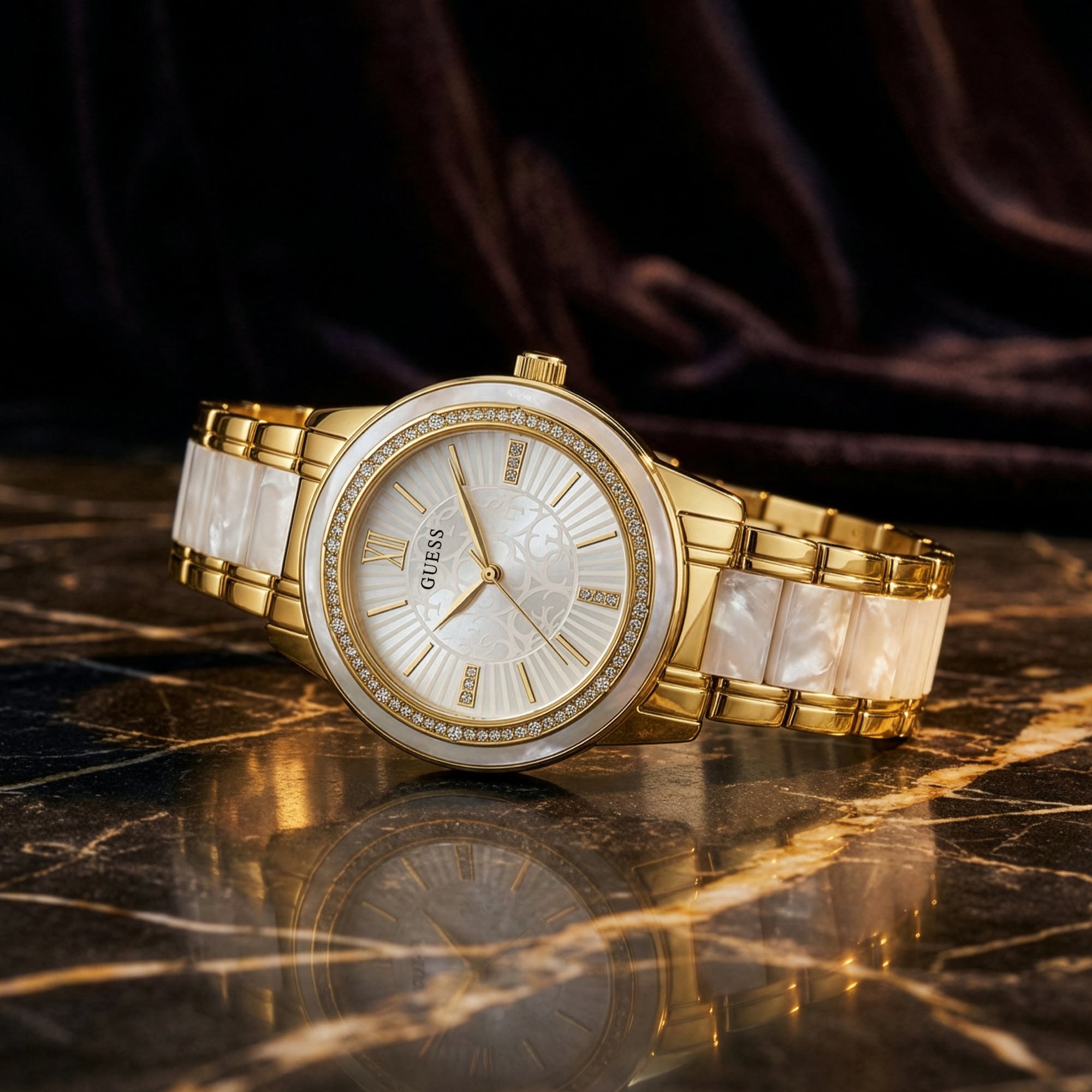 Guess Trinity gold dress sport watch reflected on the surface of a marble table.