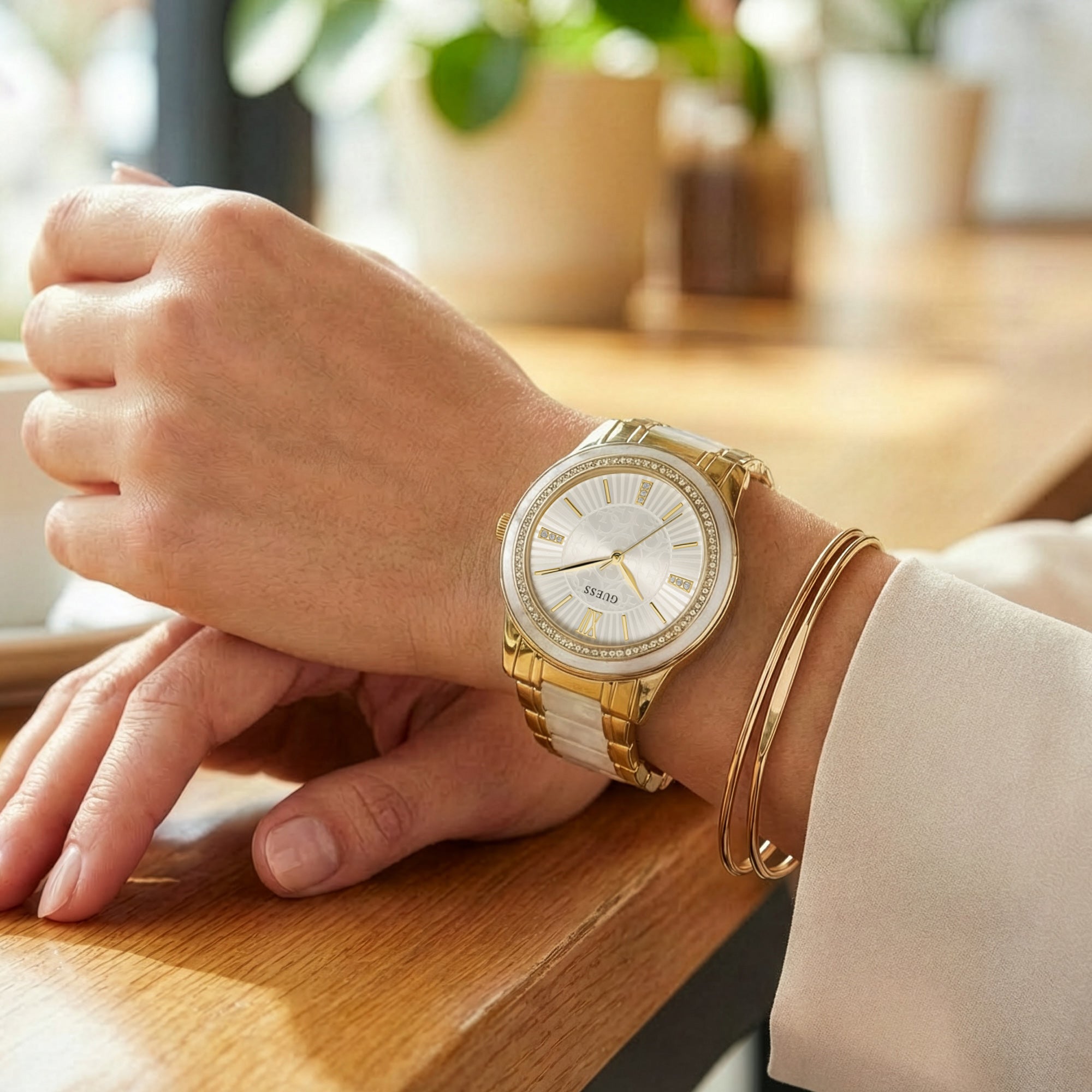 Woman wearing Guess Trinity gold dress sport watch.
