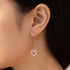 Woman wearing Engelsrufer heart pave CZ thread silver earrings.