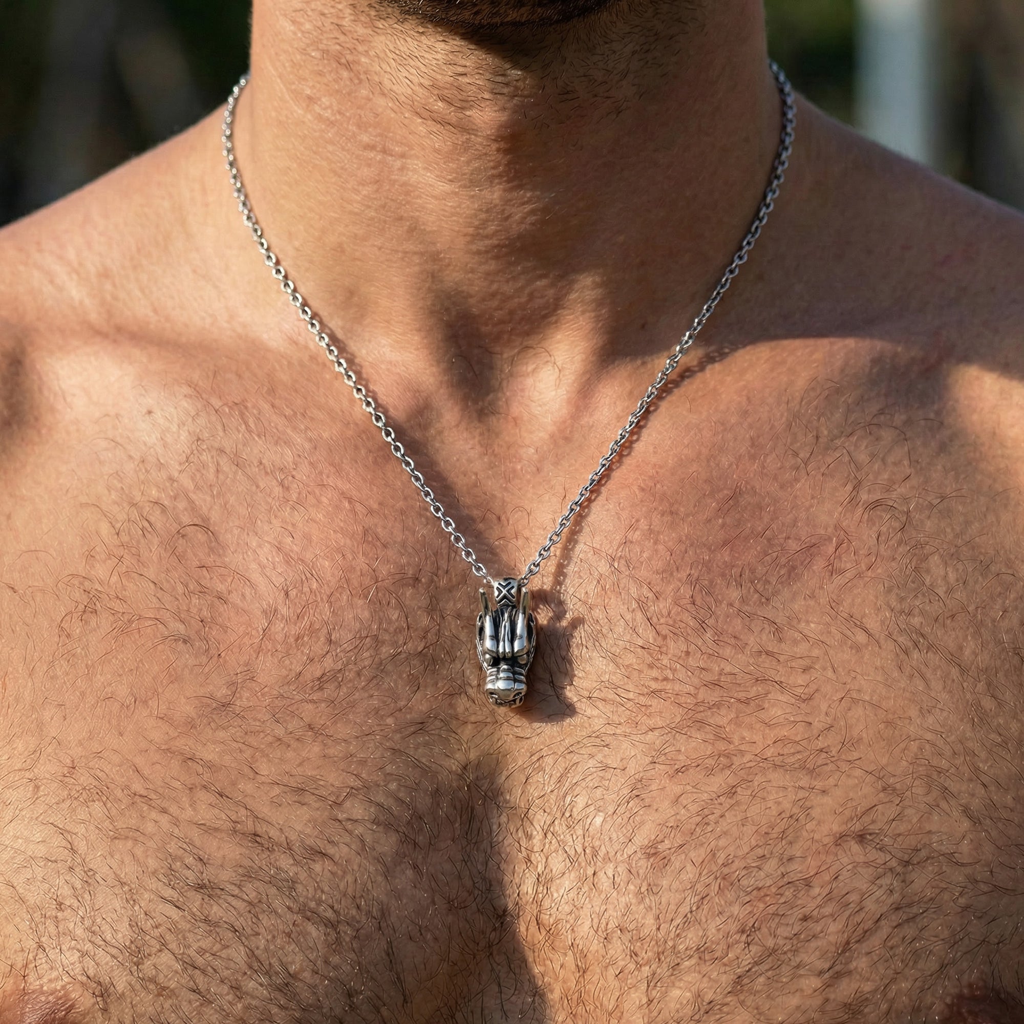 Close-up on man wearing stainless steel horned dragon head necklace.