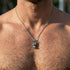 Close-up on man wearing stainless steel horned dragon head necklace.