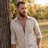 Man leaning against a tree in an open-neck shirt wearing a horned skull stainless steel medallion necklace.