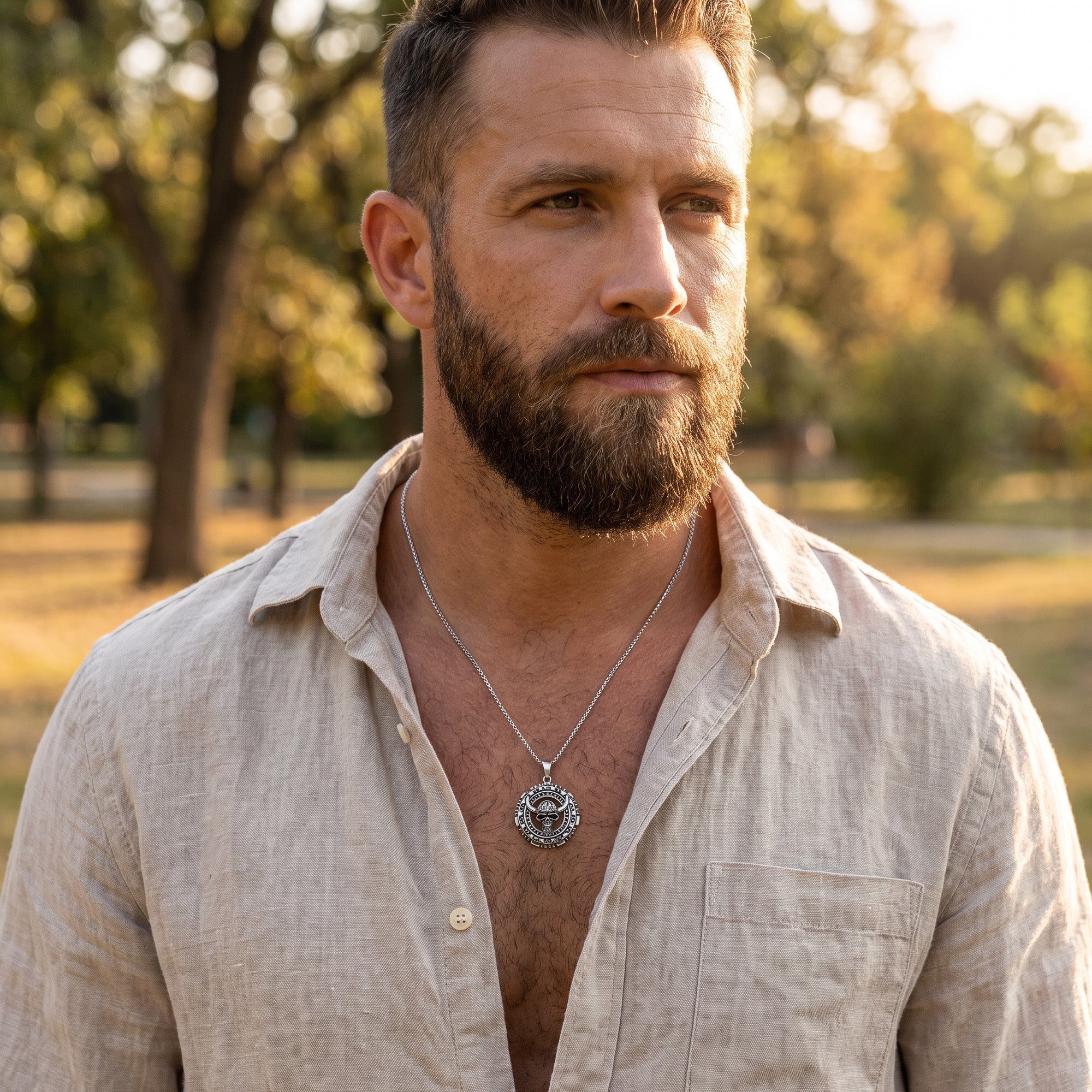 Man in an open-neck shirt wearing a horned skull stainless steel medallion necklace.
