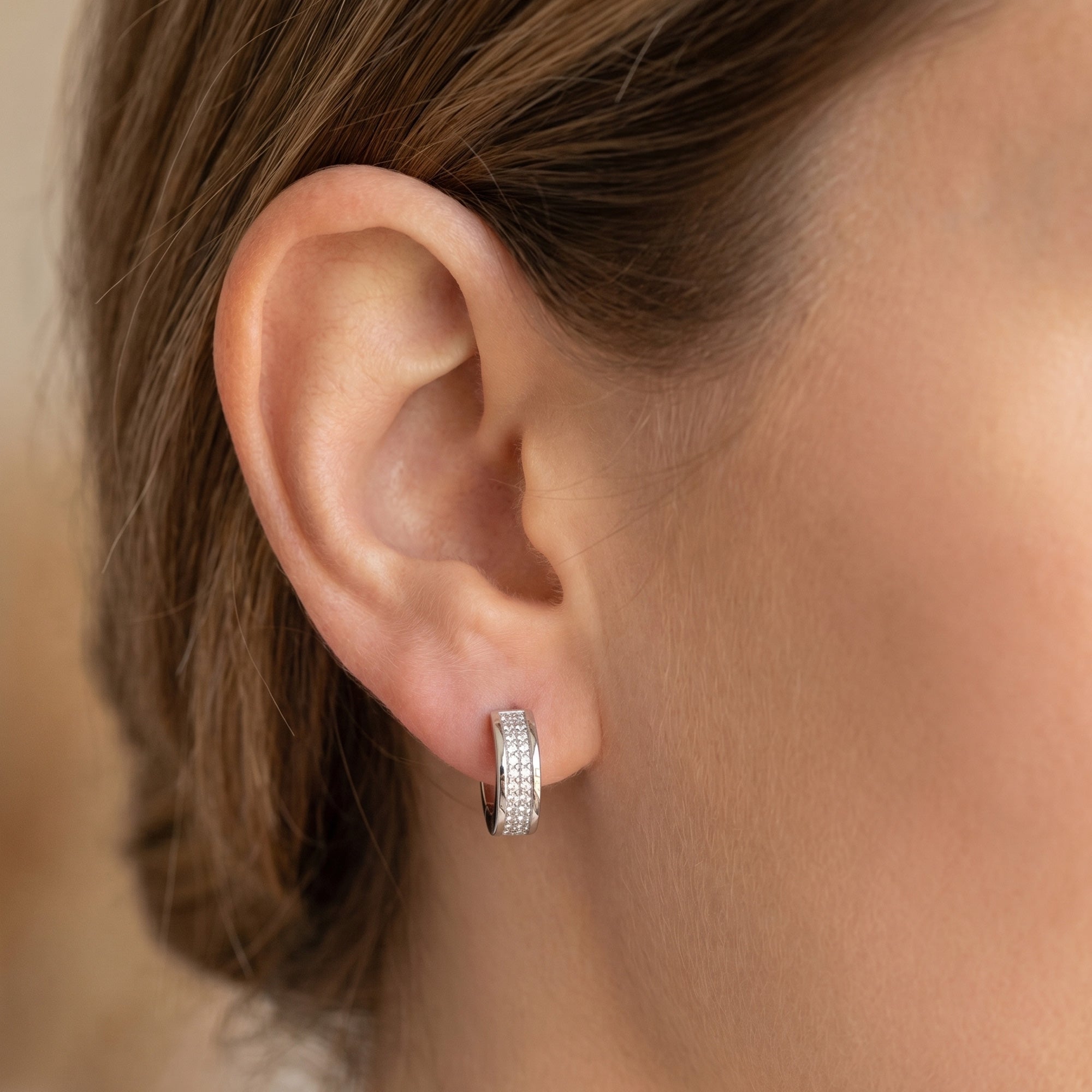 Woman wearing Engelsrufer mini huggie hoop sterling silver CZ earrings.